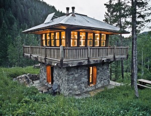 tiny home in a clearing made of stone and wood